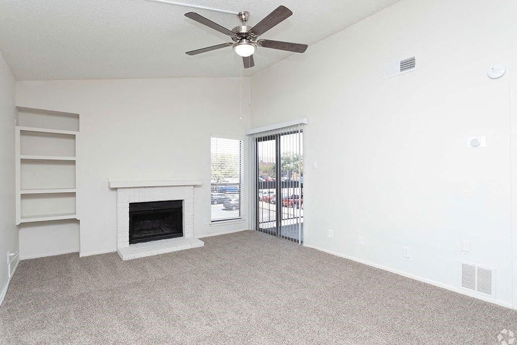 a living room with a fireplace and a sliding glass door  at Sunset Canyon, San Antonio