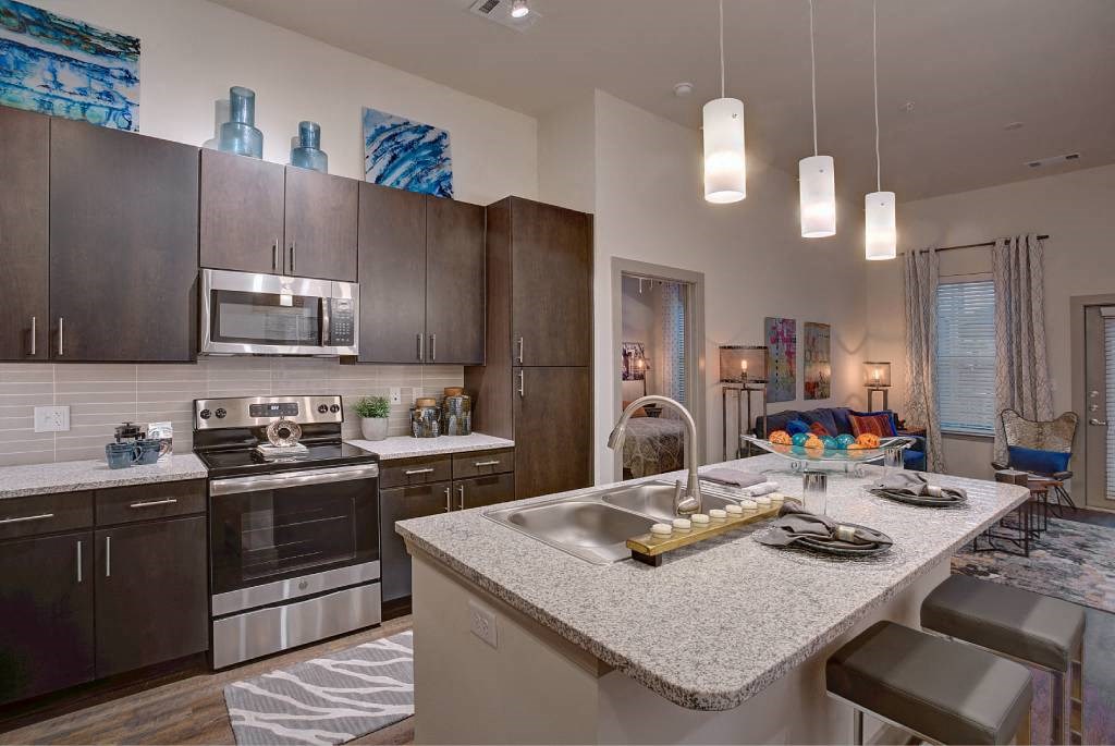 a kitchen with a counter top and a sink a kitchen with a counter top and a sink at The Grand at Stonecreek, Texas