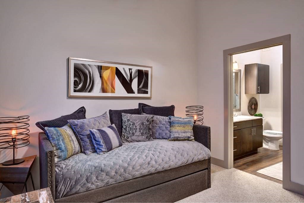 a living room with a couch and a door to a bathroom at The Grand at Stonecreek, San Marcos
