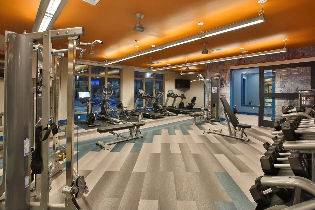 a gym with cardio machines and weights on the floor a gym with cardio machines and weights on the floor at The Grand at Stonecreek, San Marcos, TX, 78666