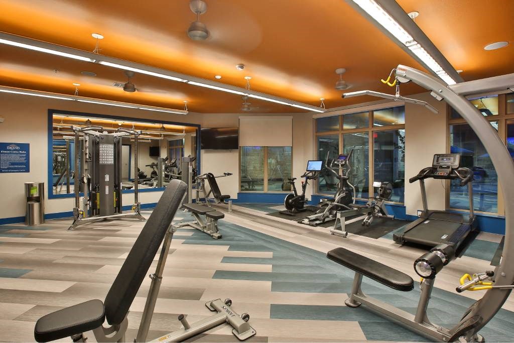 a gym with weights and a sign that says the gym is filled with weights at The Grand at Stonecreek, San Marcos, TX, 78666