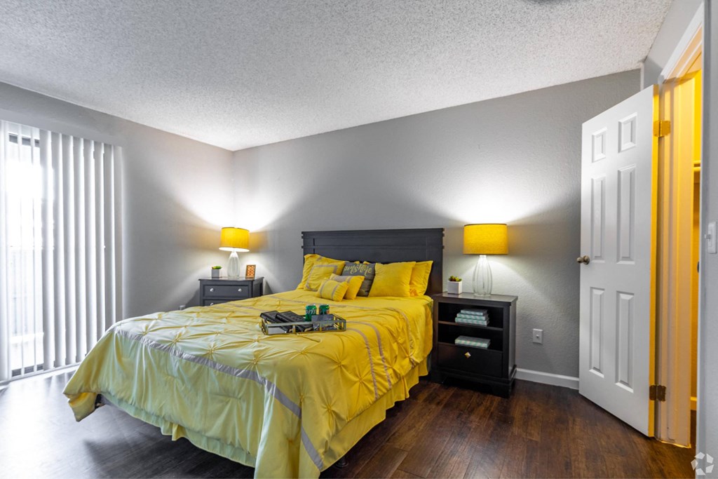 a bedroom with a yellow comforter on a bed