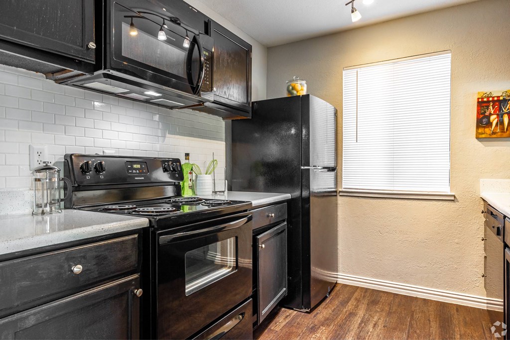 a kitchen with a stove and a microwave at Water Ridge Apartments, Irving
