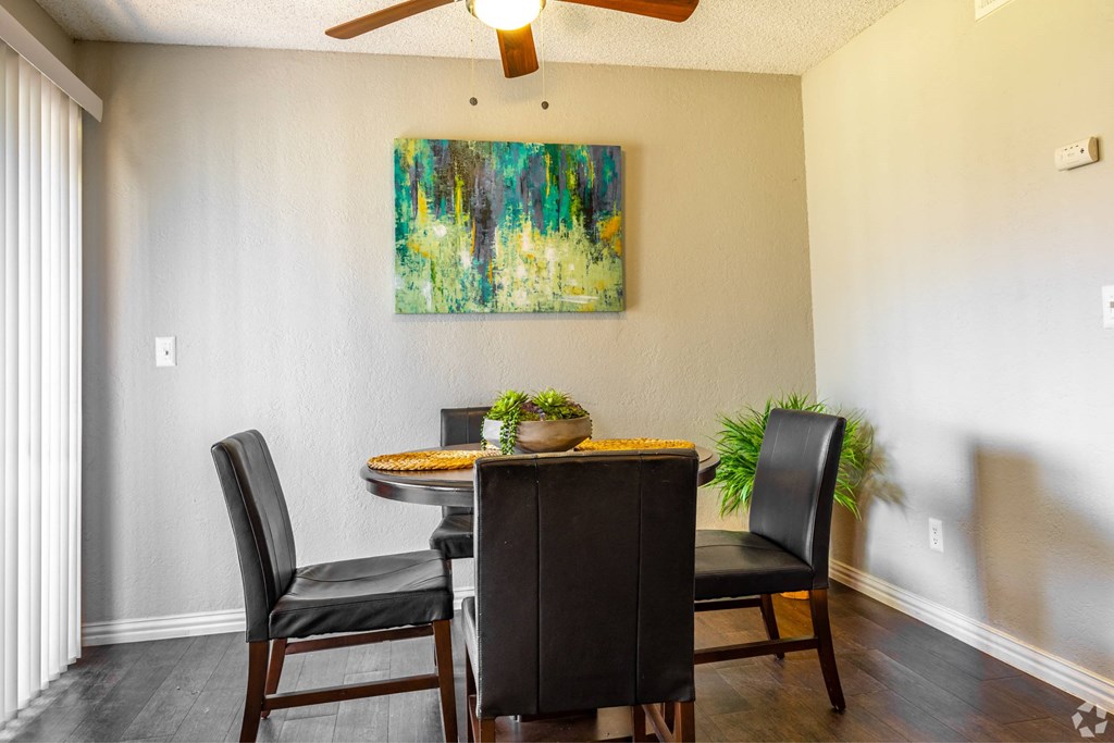 a dining room with a table and chairs and a painting on the wall at Water Ridge Apartments, Irving, 75061