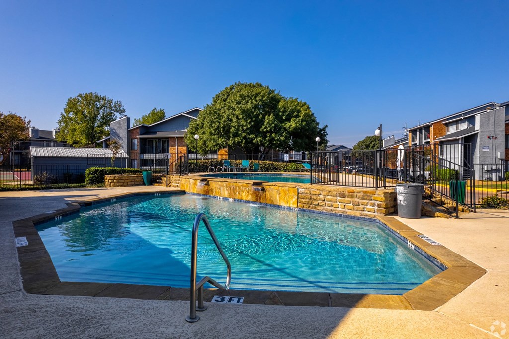a swimming pool with a reflection of a building and a fountain