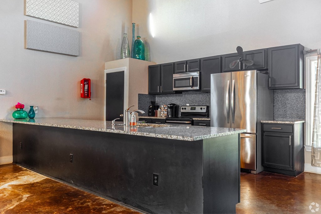 the kitchen has stainless steel appliances and a granite counter top