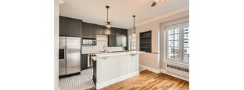 A modern kitchen with a refrigerator, sink, and cabinets.