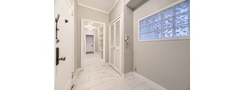 A hallway with a white door and a window with a blue tint.