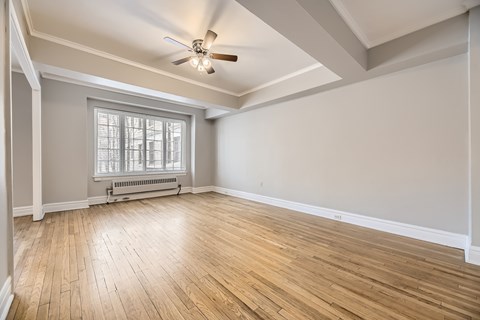 A room with wooden floors and a ceiling fan.