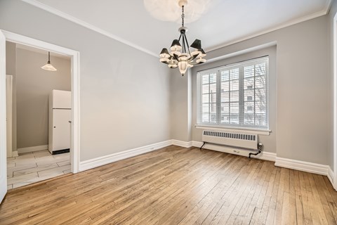 A room with wooden floors and a chandelier hanging from the ceiling.