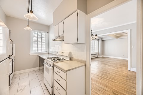 A kitchen with white appliances and cabinets.