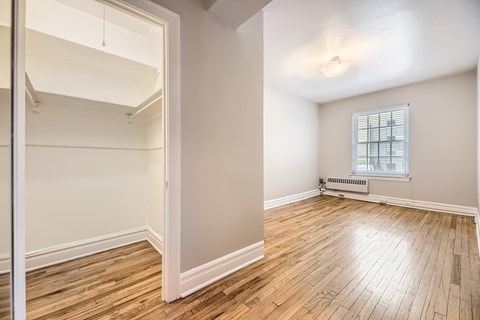 Empty room with wooden floors and a window.