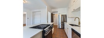 A kitchen with a stove top oven and a refrigerator.