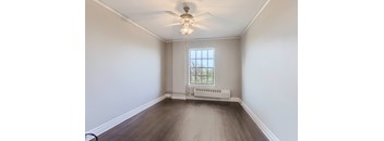 A room with a window and a ceiling fan.