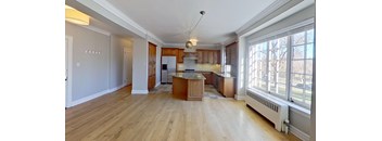 A kitchen with wooden floors and a large island in the middle.