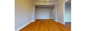 A room with wooden flooring and white walls.