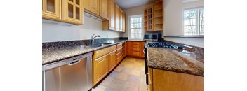 A kitchen with wooden cabinets and granite countertops.