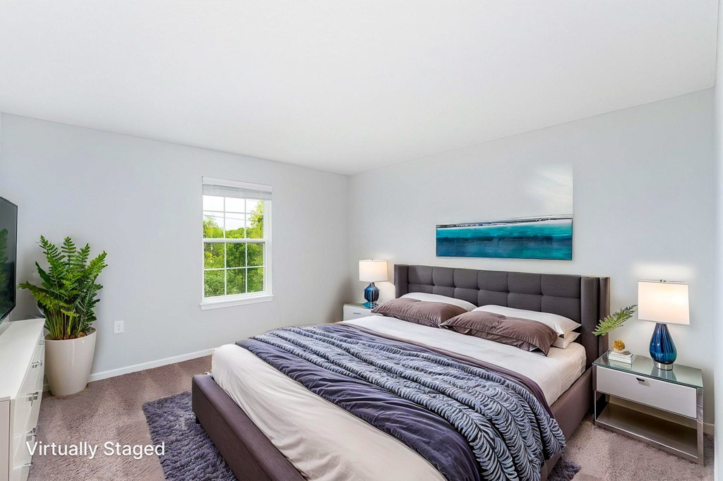A bedroom with a large bed and a window.