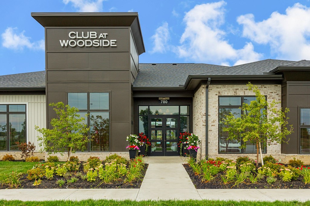 The front of the Club at Woodside building with a clear blue sky in the background.