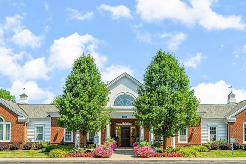 the front of a building with two trees in front of it
