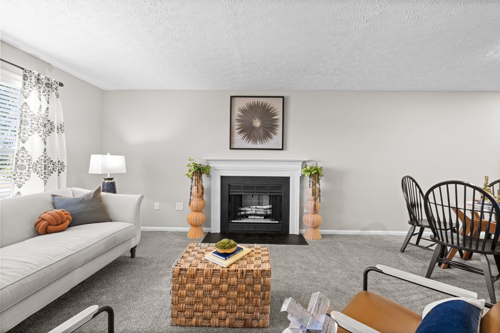 A living room with a fireplace, a couch, a chair, and a coffee table.
