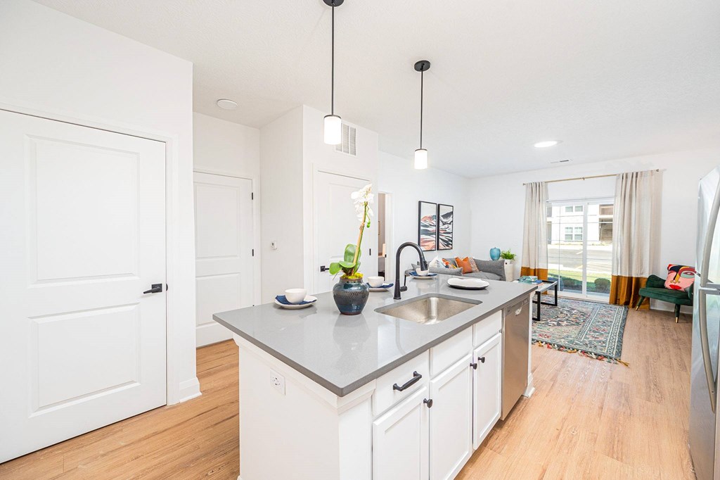 A kitchen with a white counter top and a sink.