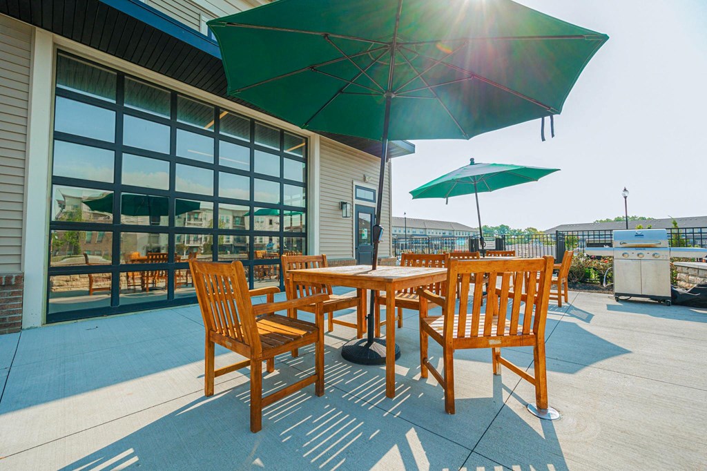 a patio with tables and umbrellas outside of a building