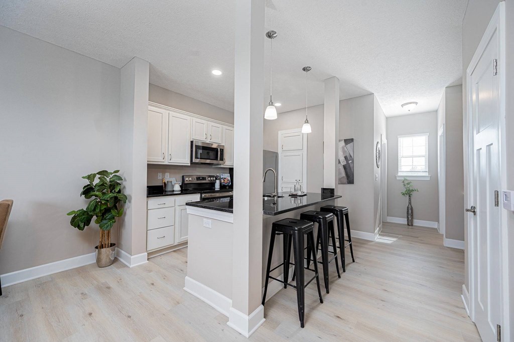 an open kitchen and dining room with bar stools
