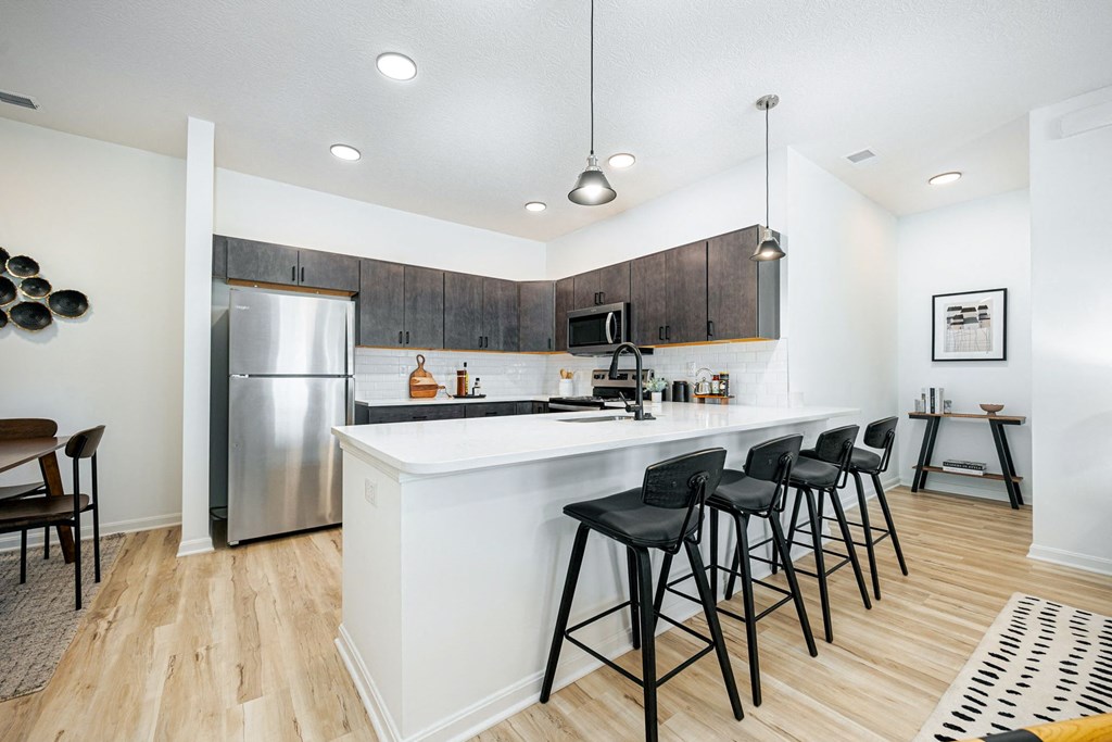 a kitchen with a large island with bar stools