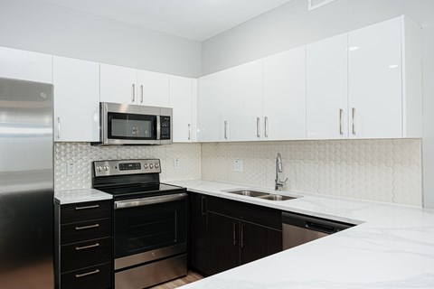 a kitchen with white counter tops and black appliances