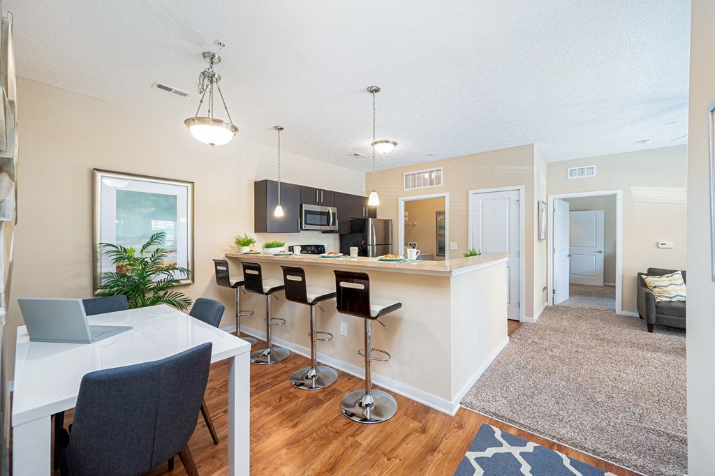 an open kitchen and dining area with a bar and a living room