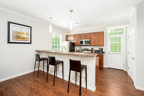 a kitchen with a bar with three stools