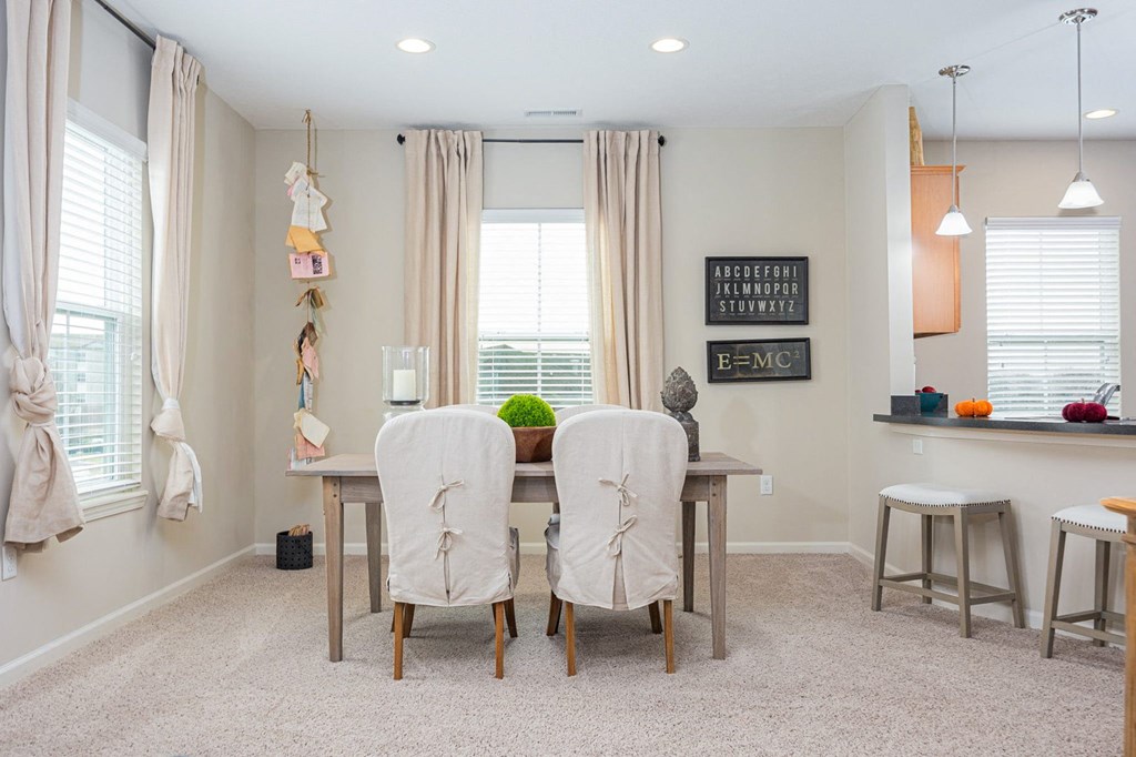 A dining room with a table and chairs.