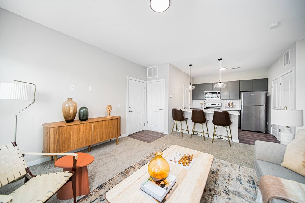A living room with a brown wooden cabinet, a grey couch, and a rug.