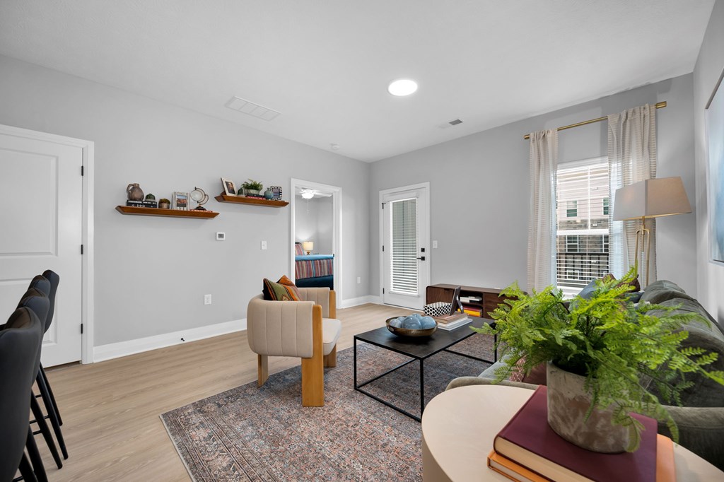 A living room with a couch, chair, and potted plant.