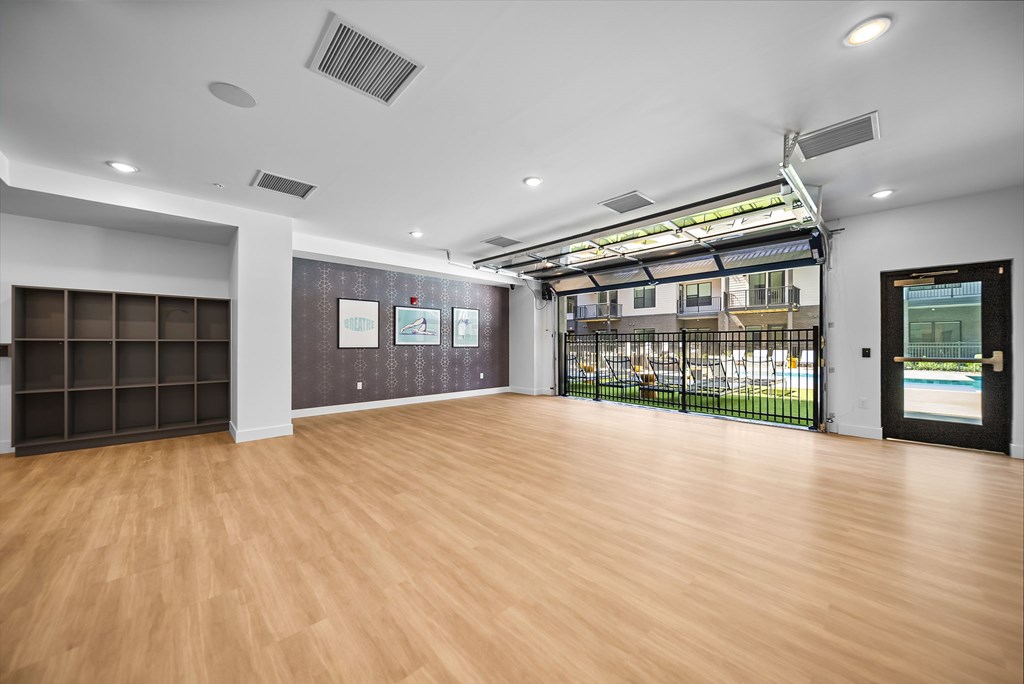 A room with wooden floors and a wall of windows.