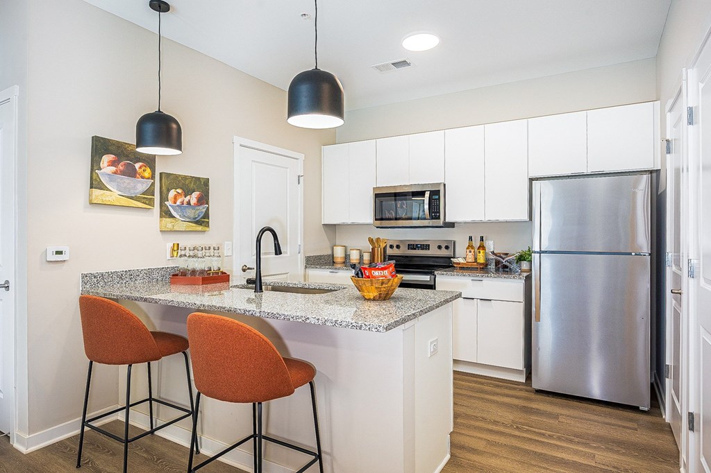 A kitchen with a granite countertop and a refrigerator.