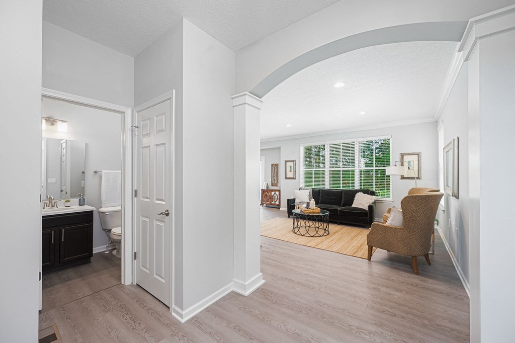 a living room with a couch and a chair and a bathroom with a sink