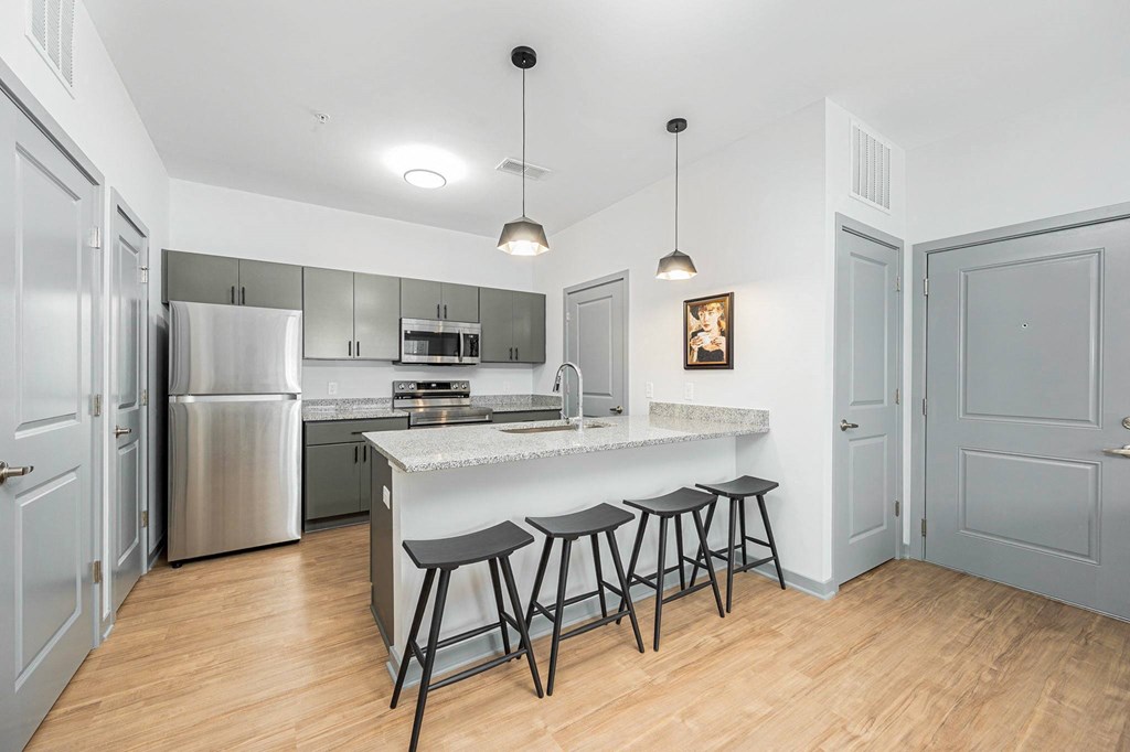a kitchen with a large island with three bar stools
