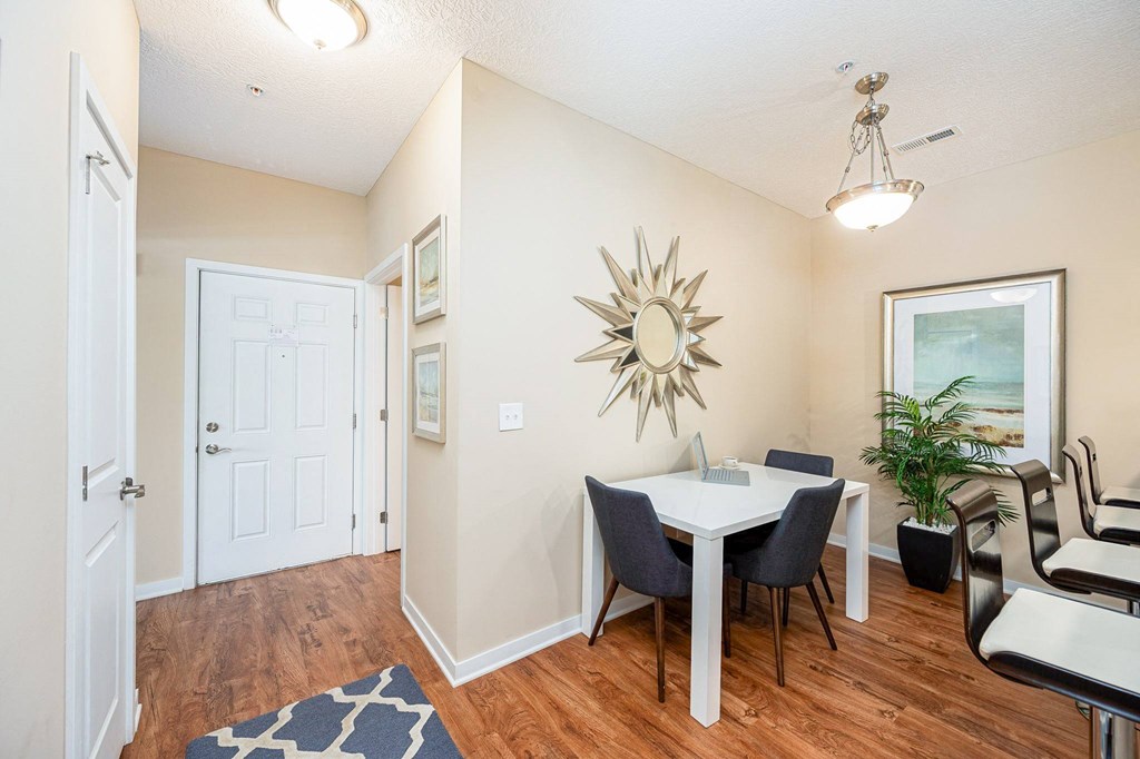 a dining room with a table and chairs and a mirror