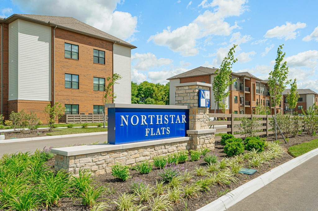 a sign flats in front of an apartment building