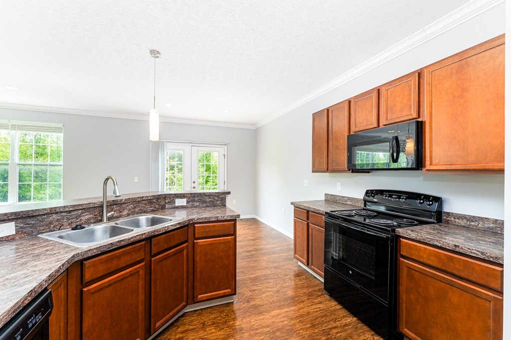 A kitchen with wooden cabinets and a black stove top oven.