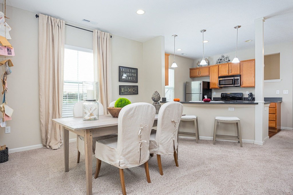 A dining room with a table and chairs.