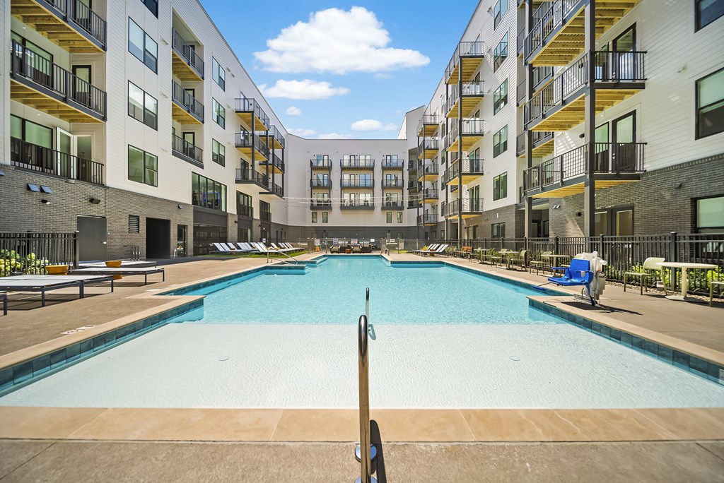 A large outdoor pool surrounded by apartment buildings.