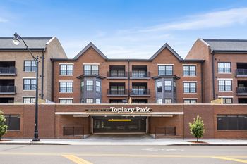 The image shows a multi-story building named Toplary Park with a parking lot in front.
