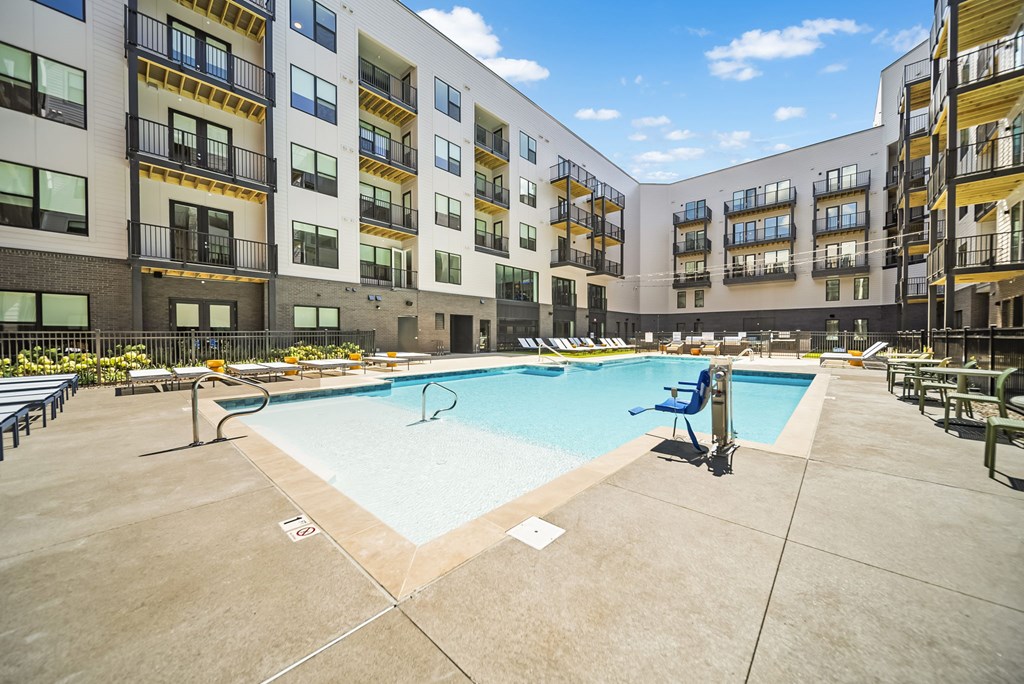 A large swimming pool in the middle of a courtyard surrounded by apartment buildings.
