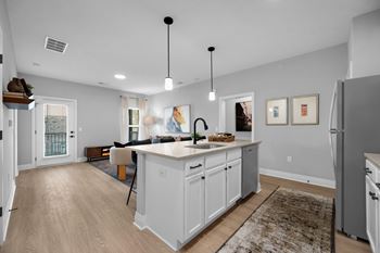 A kitchen with white cabinets and a large island.