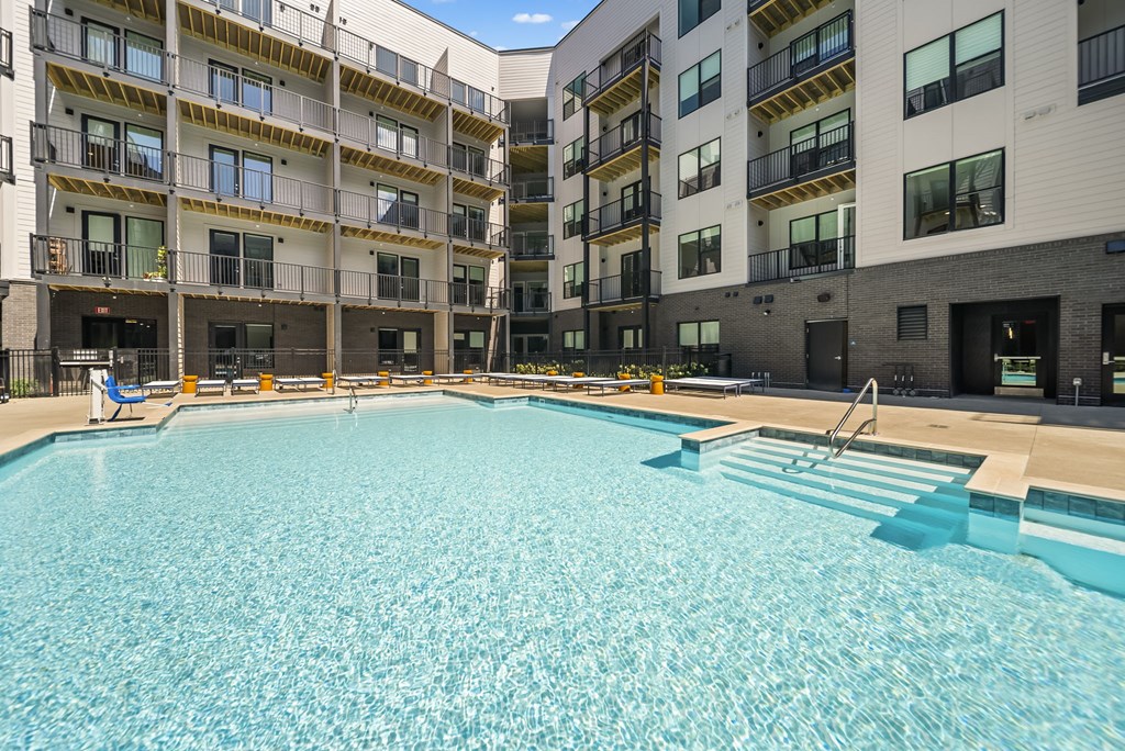 A large swimming pool in front of apartment buildings.