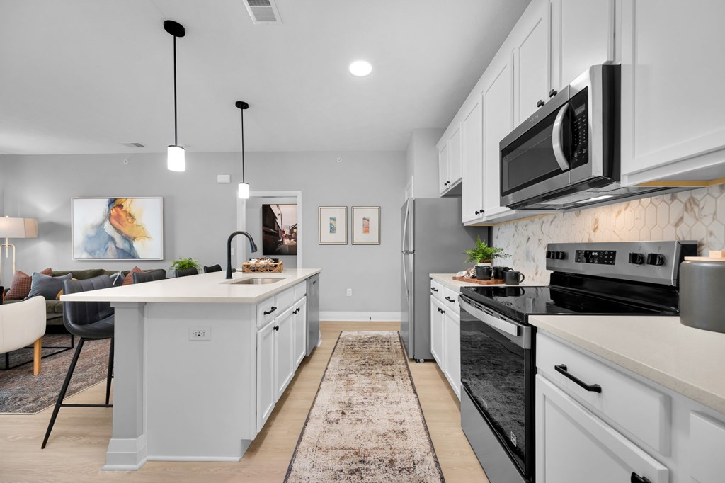 A modern kitchen with a large island and stainless steel appliances.