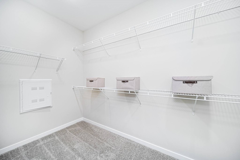 A white room with three shelves and a white wall.